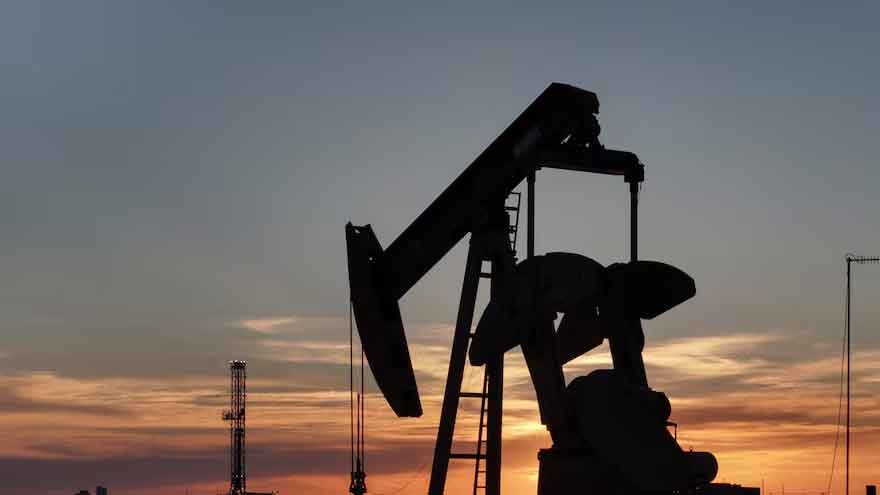 Oil barrels and market charts amid rising crude prices and Strait of Hormuz tensions