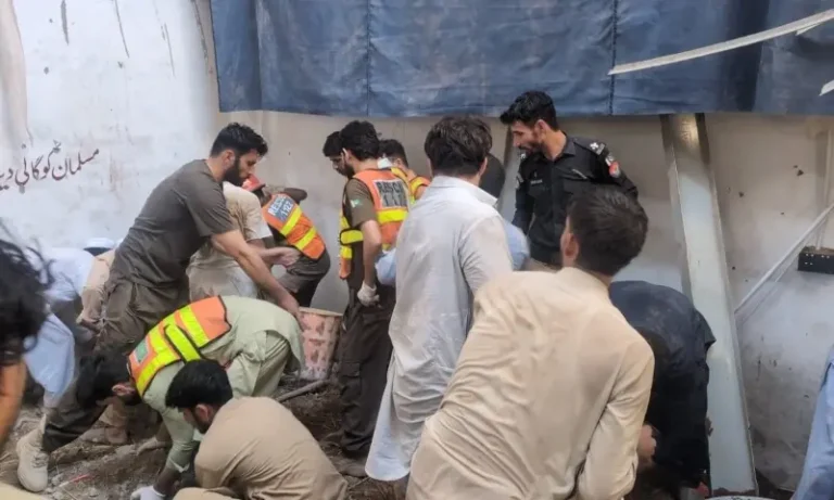 Rescue workers search debris after the Peshawar school collapse in Dir Colony.